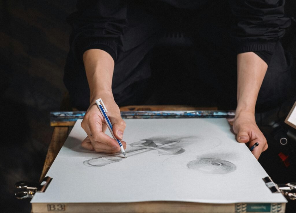 Close-up of an artist sketching with pencil and charcoal on paper in Tokyo studio.